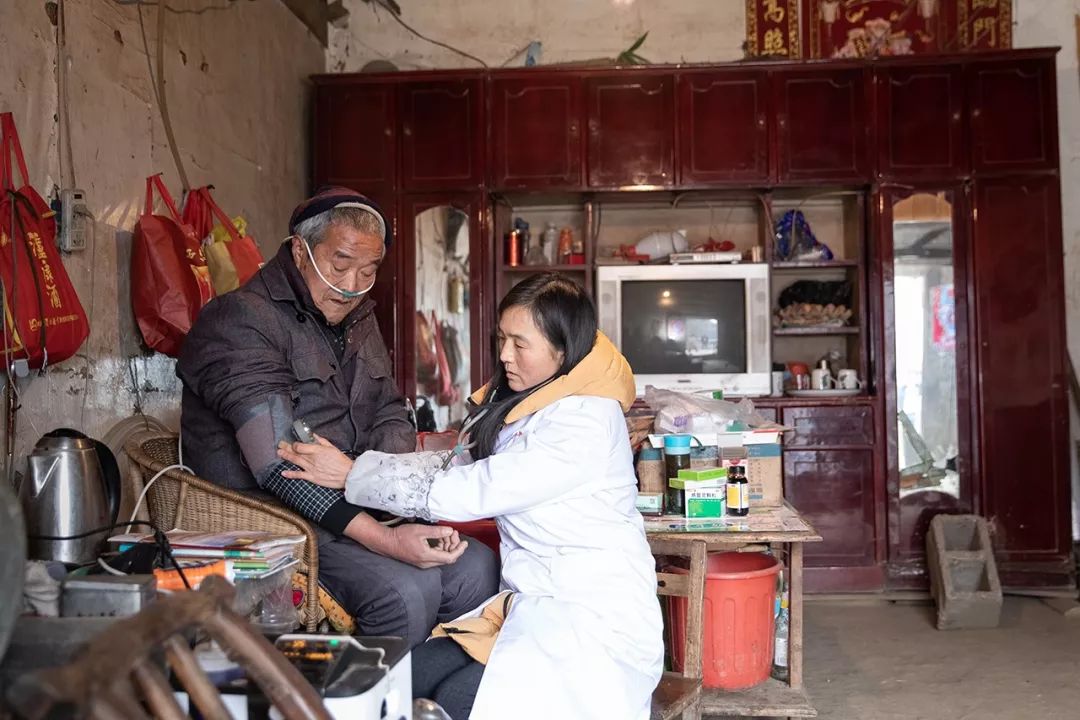Qin Renxiu is examine the blood pressure of a resident