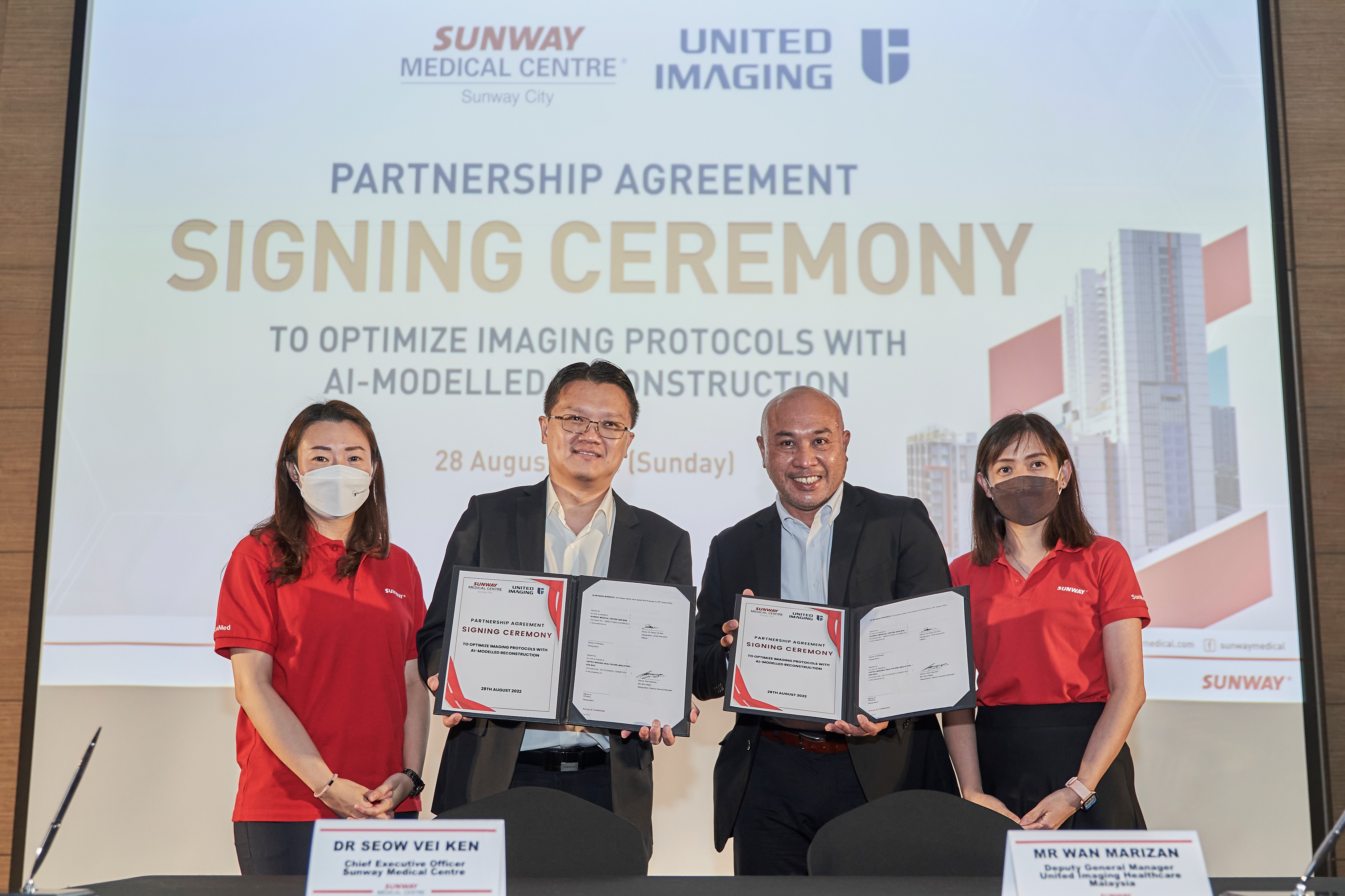 Dr Seow Vei Ken and Wan Marizan Wan Majid with United-imaging on a partnership agreement ceremony to optimise molecular imaging protocols using AI. 